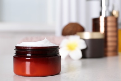 Jar of body care product on table against blurred background. Space for text