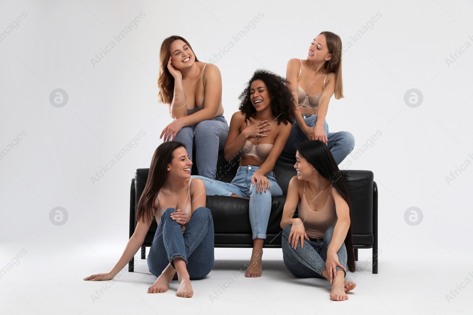 Photo of Group of women with different body types in jeans and underwear on light background