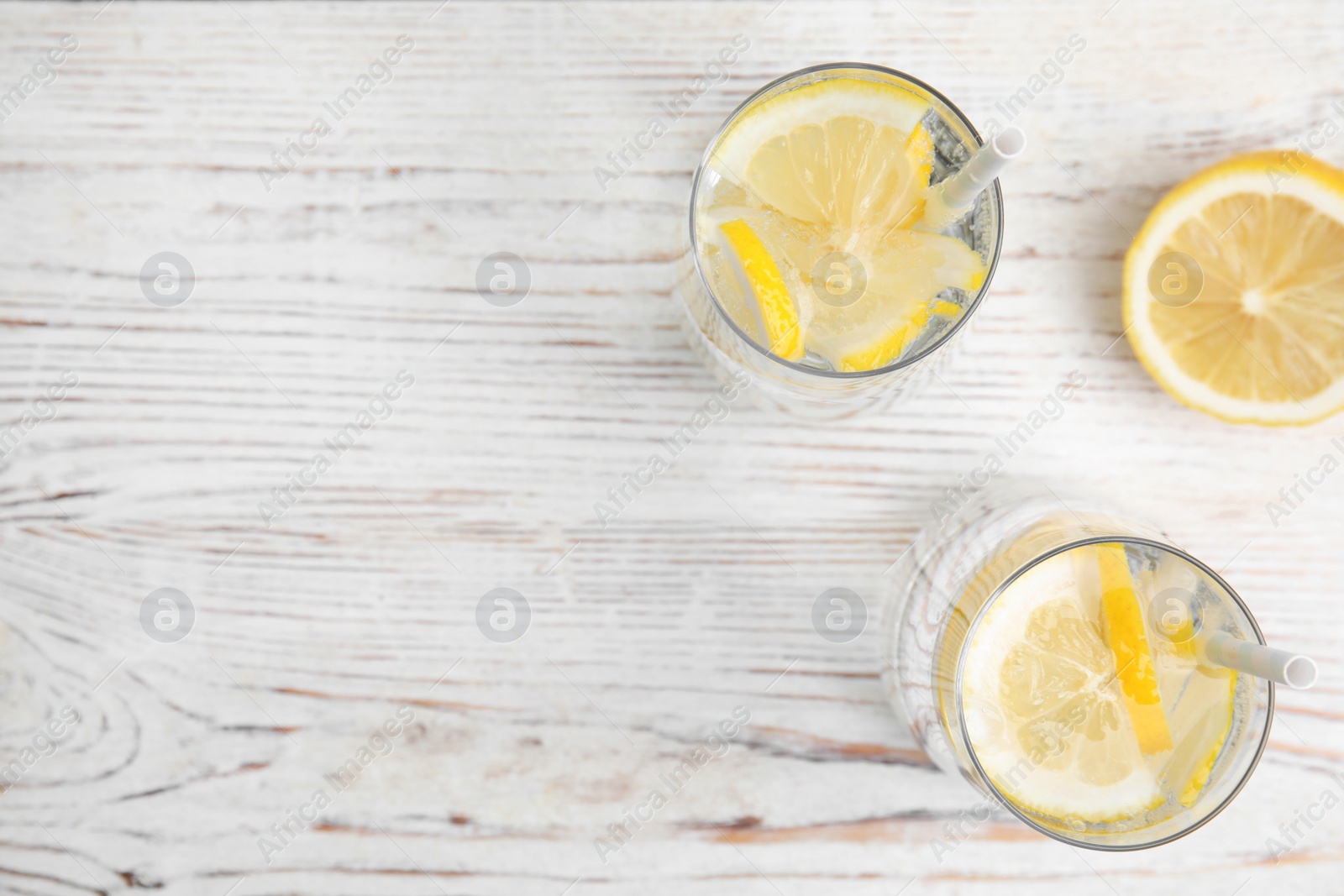 Photo of Soda water with lemon slices on white wooden table, flat lay. Space for text