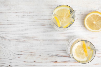 Photo of Soda water with lemon slices on white wooden table, flat lay. Space for text