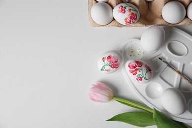 Photo of Painting Easter eggs on white table, flat lay. Space for text