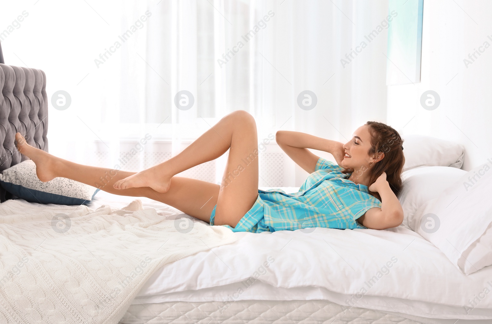 Photo of Young woman doing exercise on bed at home. Morning fitness