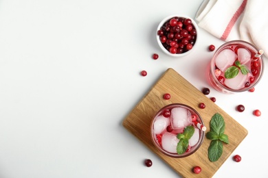 Photo of Tasty refreshing cranberry cocktail with mint on white table, flat lay. Space for text