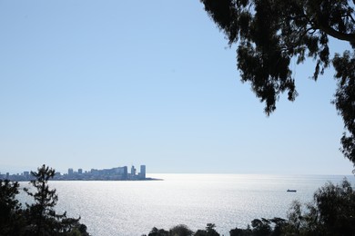 Photo of Picturesque view of beautiful sea and distant city under blue sky