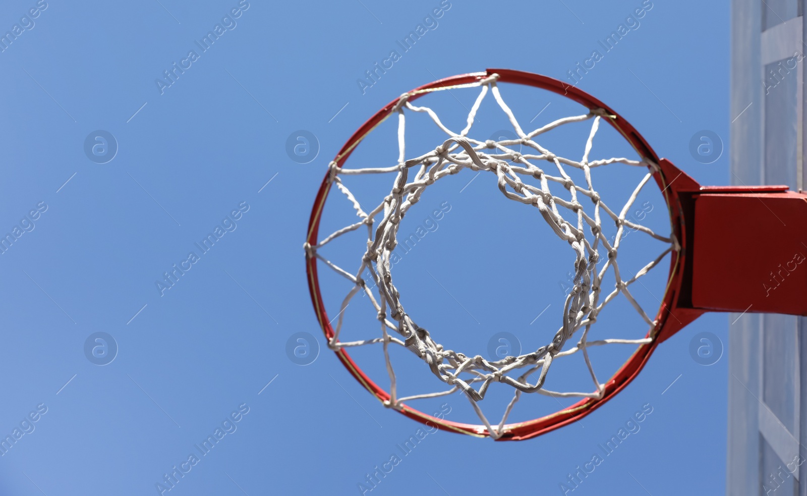 Photo of Basketball hoop with net outdoors on sunny day, bottom view. Space for text