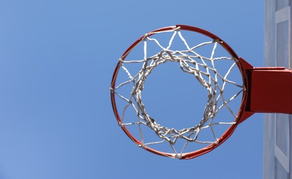 Photo of Basketball hoop with net outdoors on sunny day, bottom view. Space for text