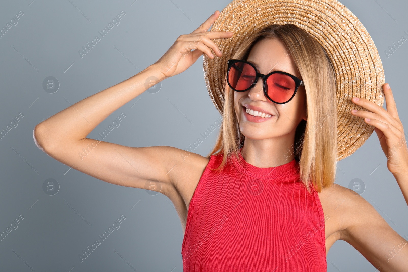 Photo of Beautiful woman in stylish sunglasses on grey background