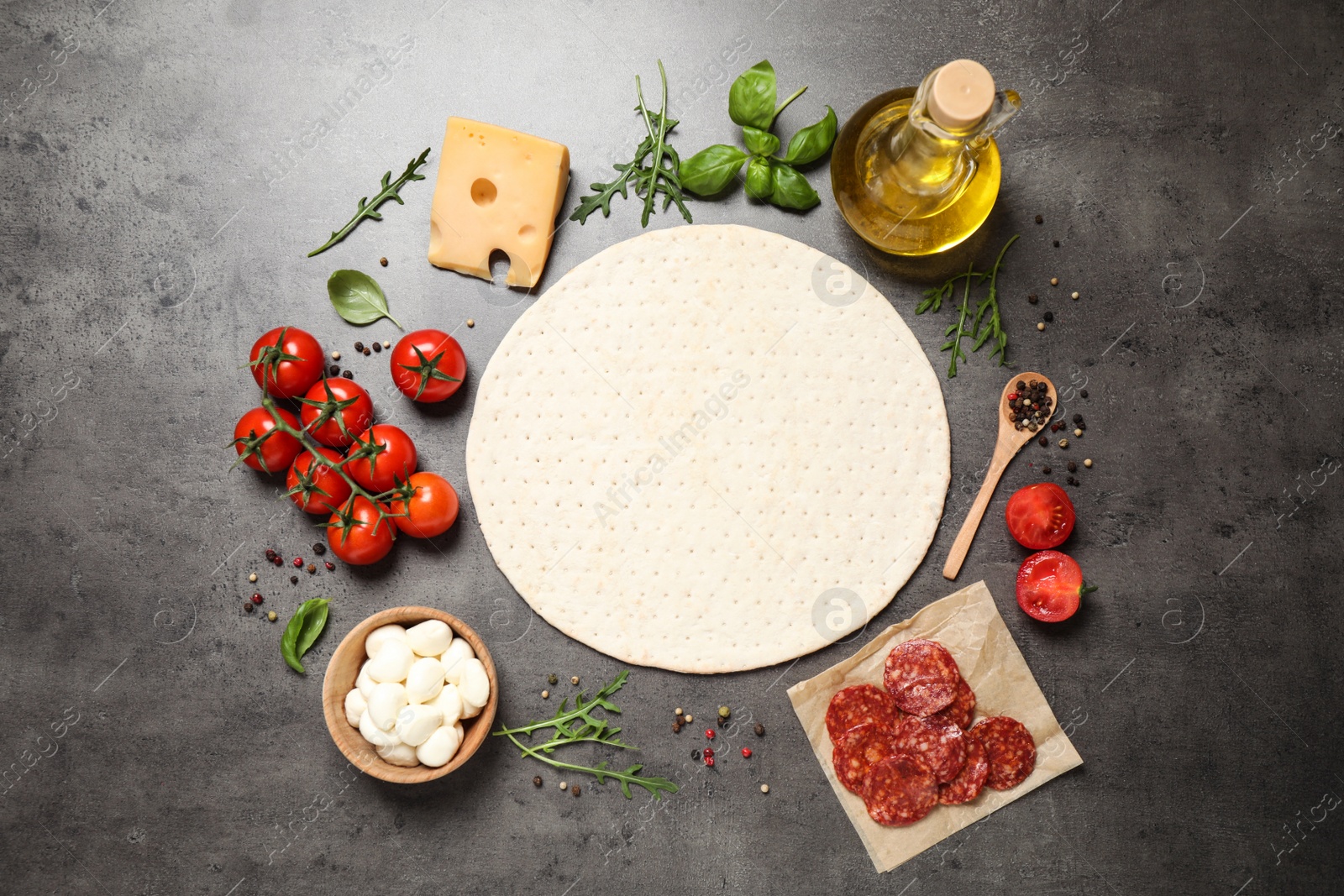Photo of Flat lay composition with base and fresh ingredients for pepperoni pizza on grey table