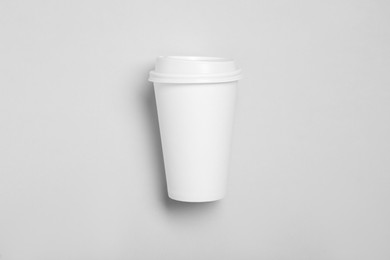 Takeaway paper coffee cup on light grey background, top view