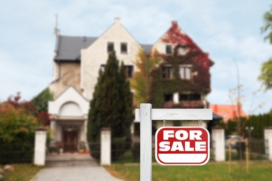 Image of Red sign with words For Sale near new house outdoors. Space for text