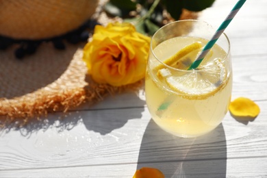 Photo of Composition with glass of lemonade and beautiful rose on white wooden table. Space for text