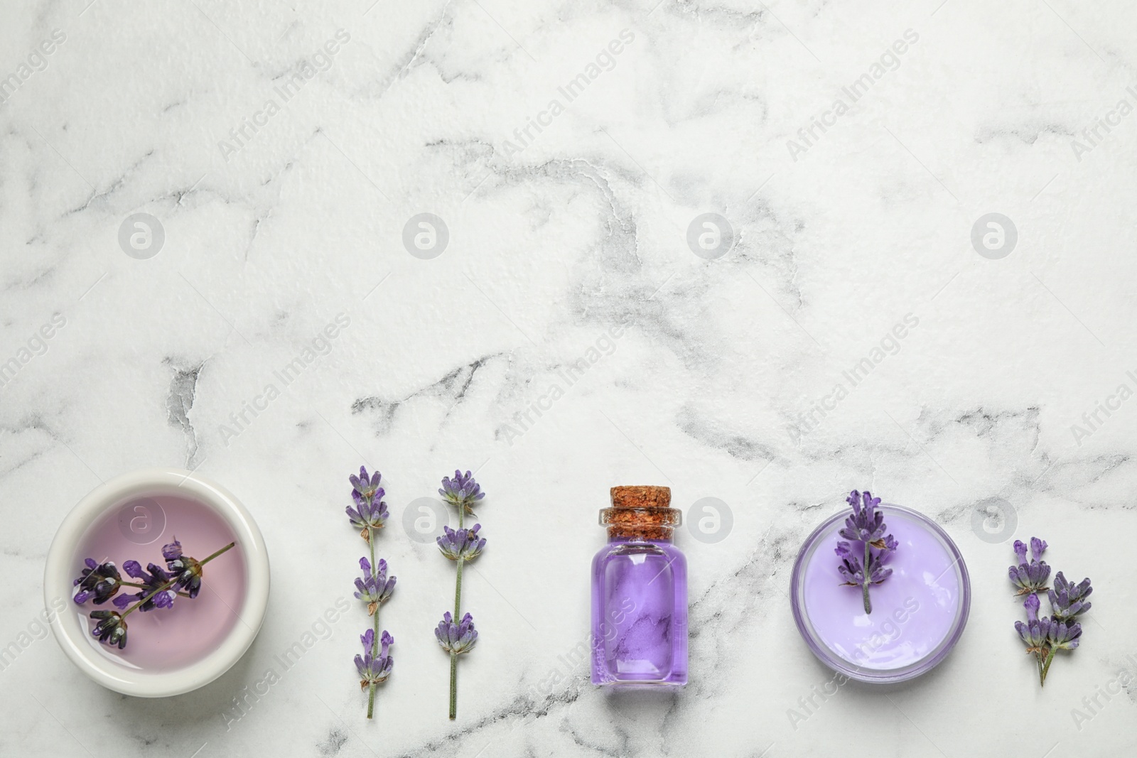 Photo of Cosmetic products and lavender flowers on white marble table, flat lay. Space for text