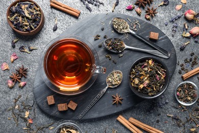 Photo of Flat lay composition with freshly brewed tea and dry leaves on grey table