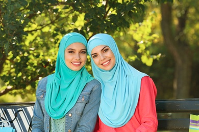 Photo of Muslim women sitting on bench in park