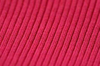 Texture of soft red knitted fabric as background, closeup