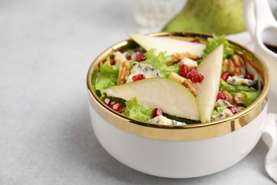 Photo of Delicious pear salad in bowl on light table, closeup. Space for text