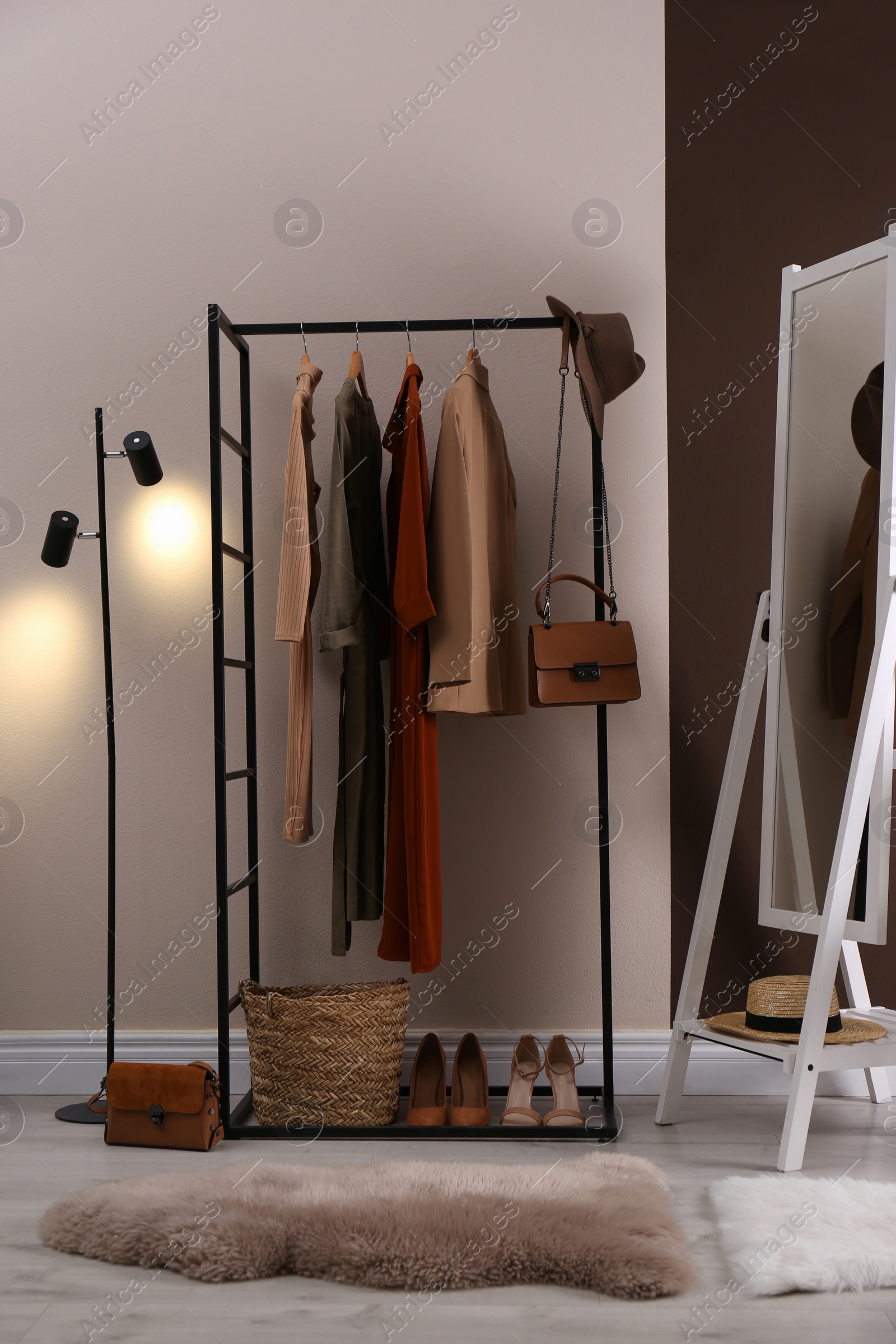 Photo of Modern dressing room interior with clothing rack and mirror