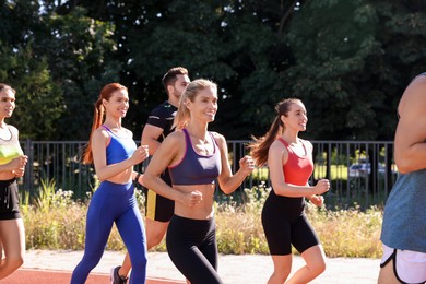 Group of people running outdoors on sunny day