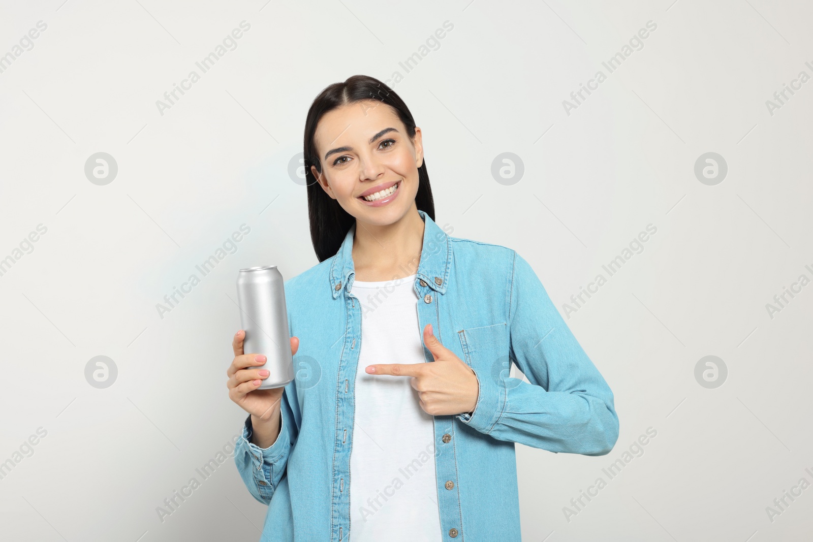 Photo of Beautiful happy woman holding beverage can on light grey background