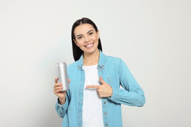 Photo of Beautiful happy woman holding beverage can on light grey background