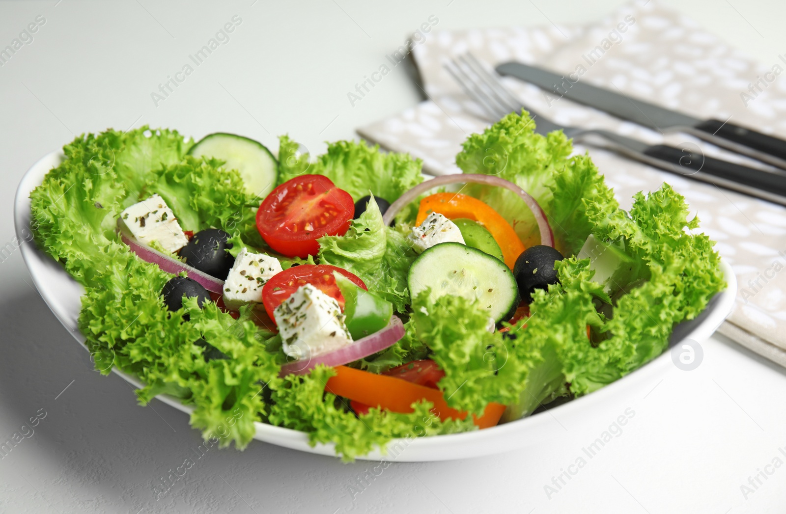 Photo of Tasty fresh Greek salad on white table, closeup