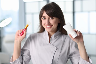 Cosmetologist with silicone brush and cosmetic product in clinic