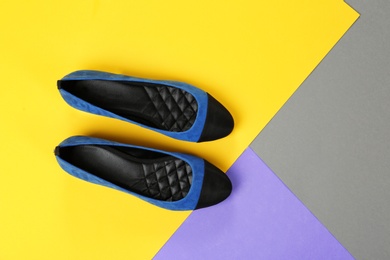 Pair of female shoes on color background, top view