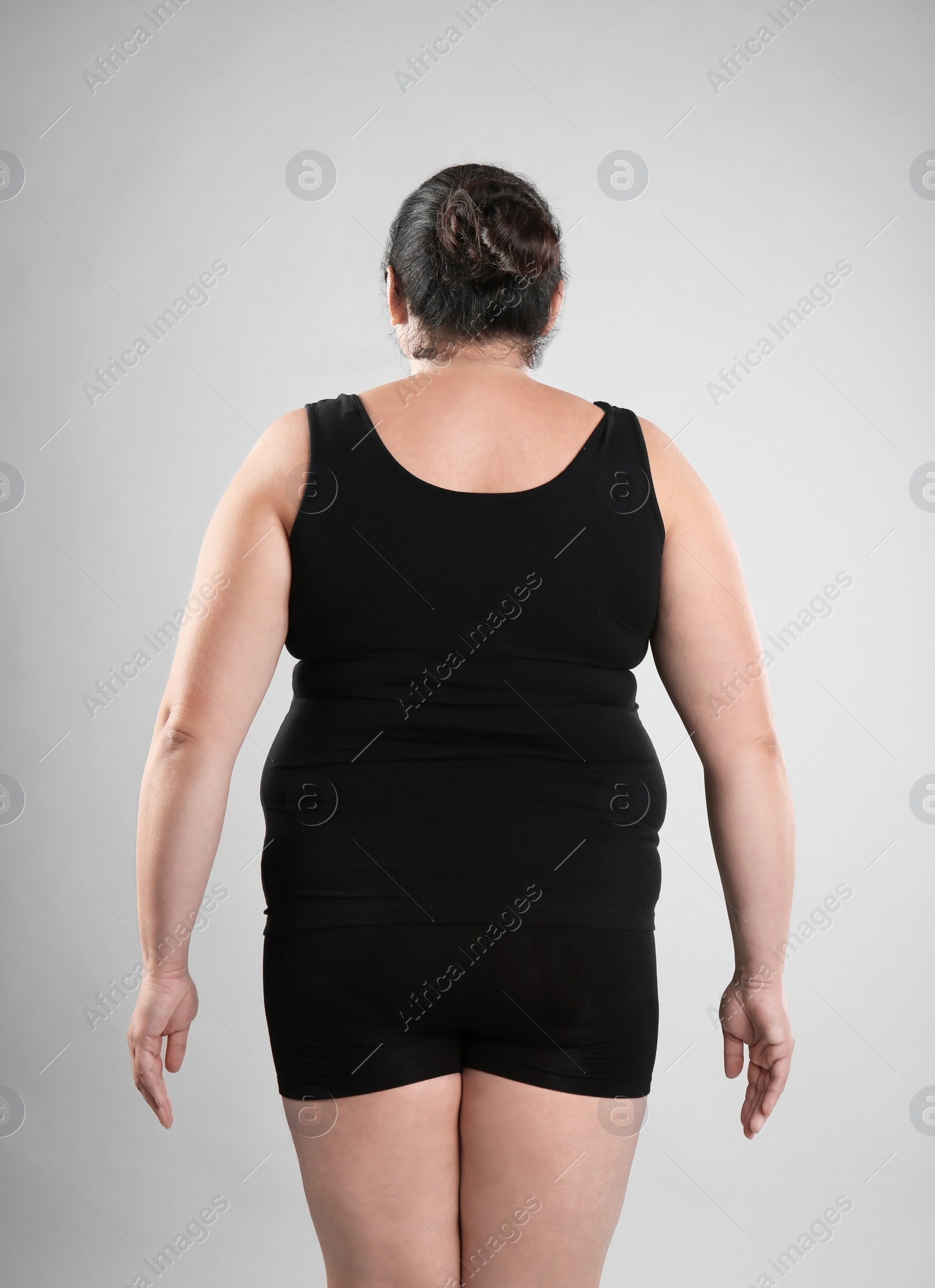 Photo of Fat woman on grey background. Weight loss