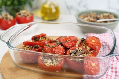Delicious stuffed tomatoes with minced beef, bulgur and mushrooms in glass baking dish, closeup
