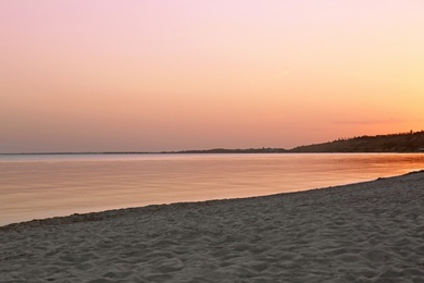 Sandy beach near sea at summer sunset