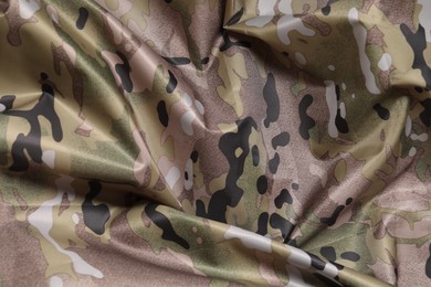 Photo of Texture of crumpled camouflage fabric as background, top view