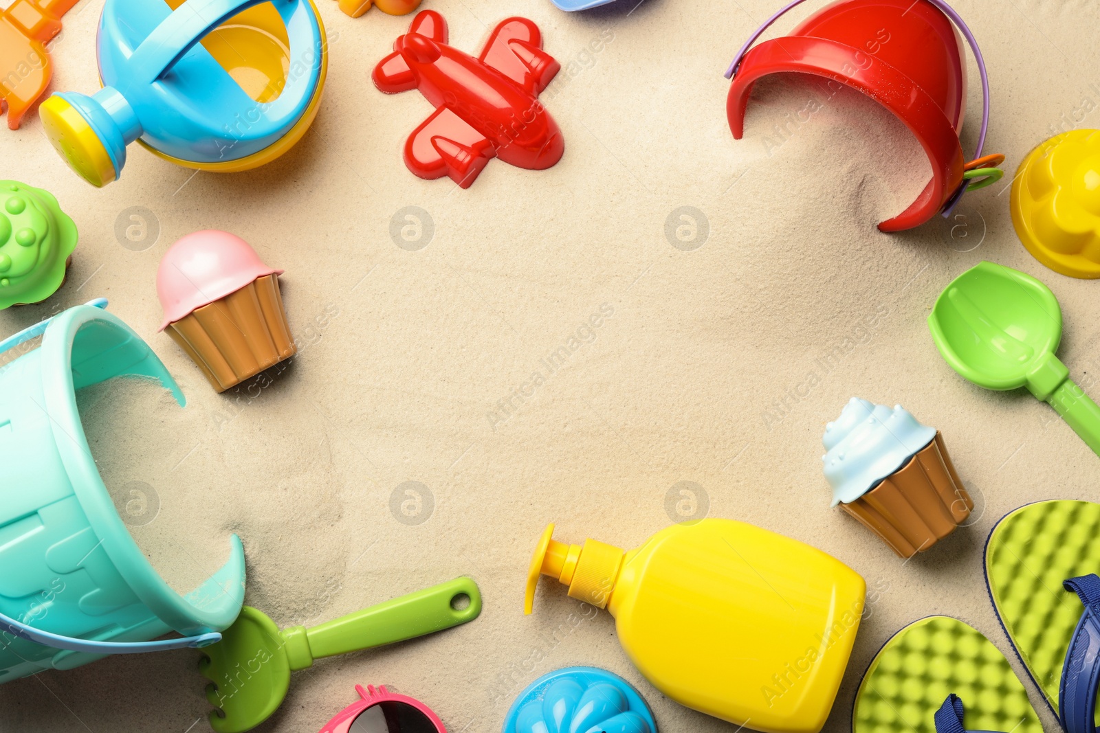 Photo of Flat lay composition with beach toys on sand. Space for text