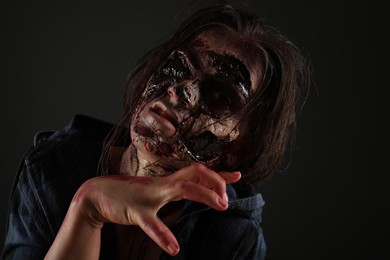 Photo of Scary zombie on dark background. Halloween monster