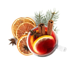 Photo of Glass cup of mulled wine, dried orange and fir branch on white background, top view