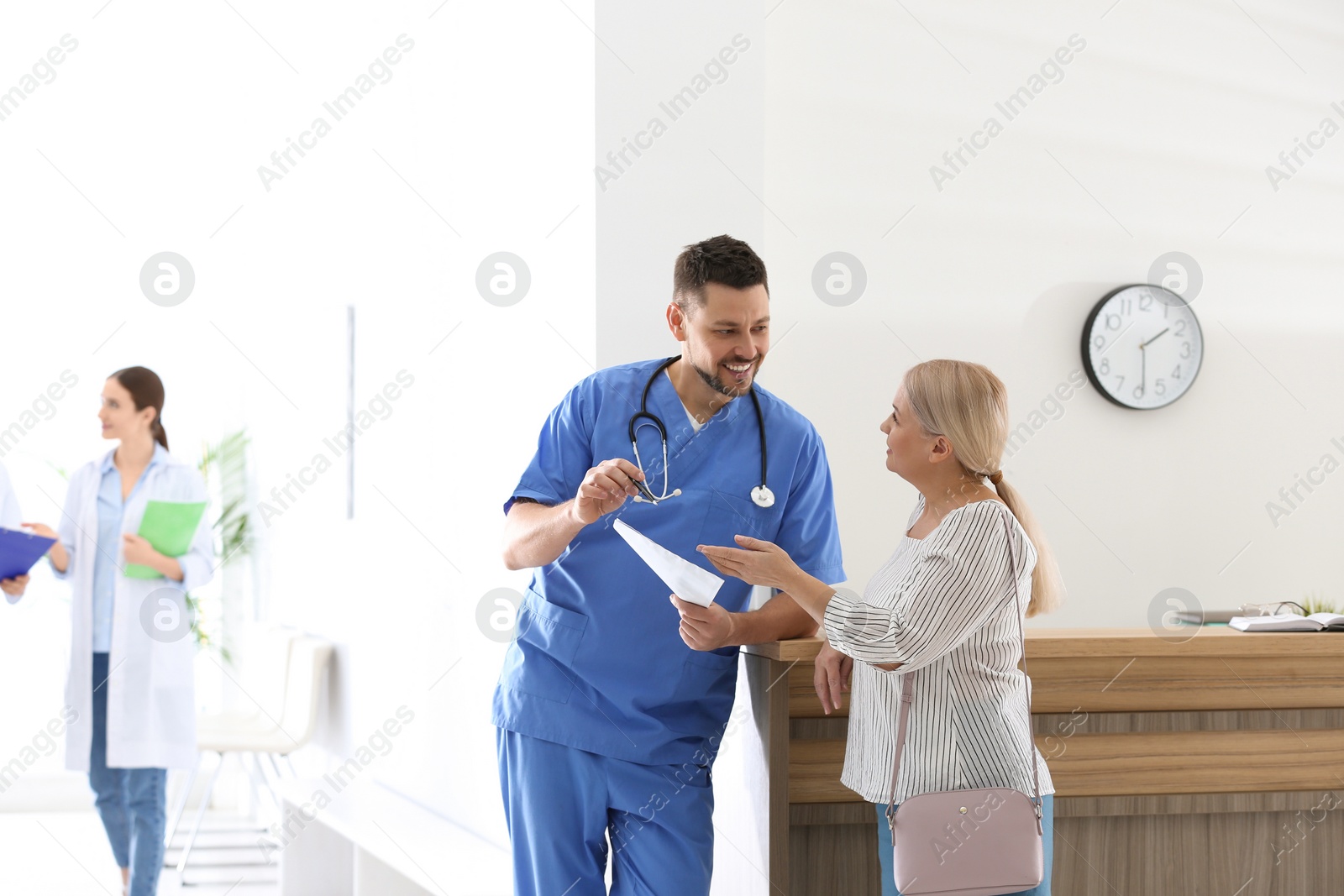 Photo of Doctor talking with patient in hospital hall