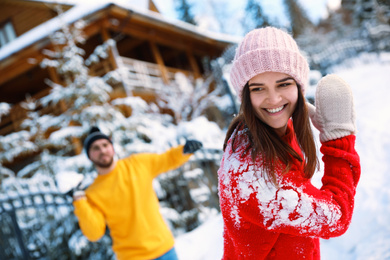 Photo of Happy couple playing snowballs outdoors. Winter vacation