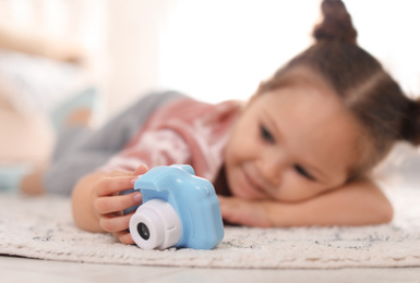 Photo of Little photographer indoors, focus on hand with camera