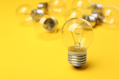 New incandescent lamp bulb on yellow background. Space for text