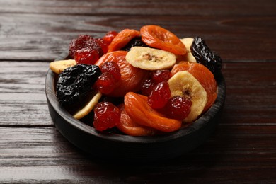 Photo of Mix of delicious dried fruits on wooden table