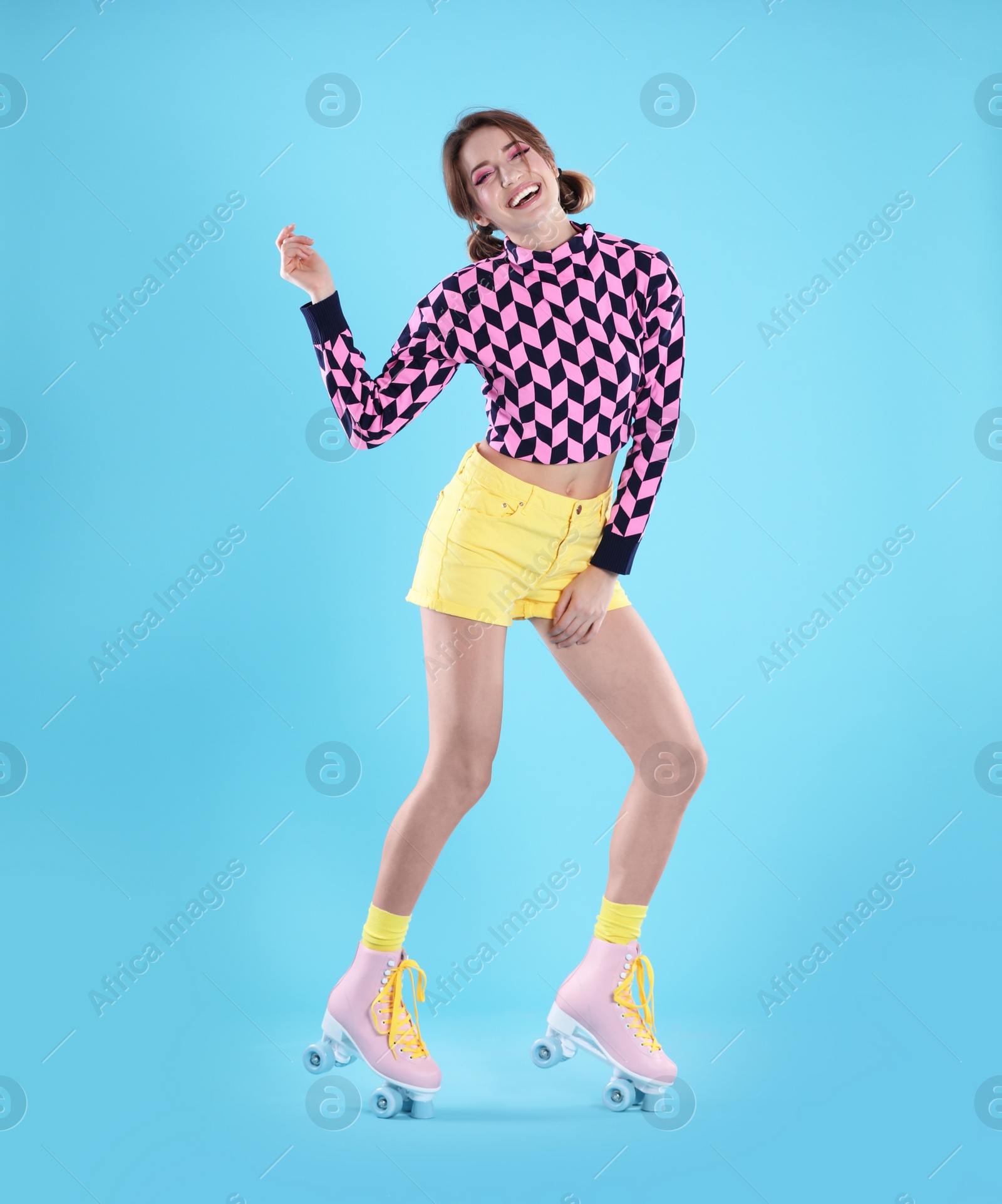 Photo of Young woman with retro roller skates on color background