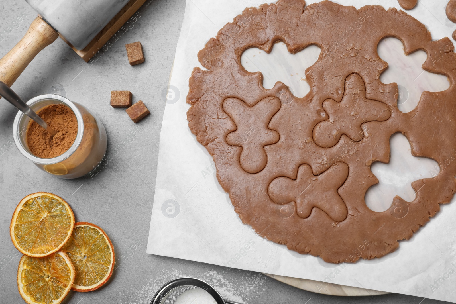 Photo of Flat lay composition with homemade gingerbread man cookies on grey table