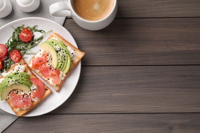 Delicious sandwiches and coffee on wooden table, flat lay. Space for text