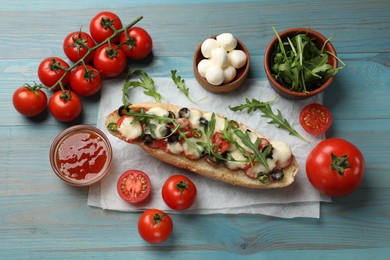 Tasty pizza toast and ingredients on light blue wooden table, top view