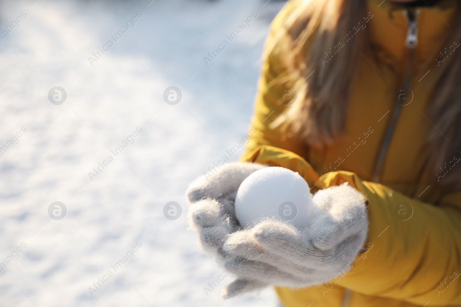 Photo of Woman holding snowball outdoors on winter day, closeup. Space for text