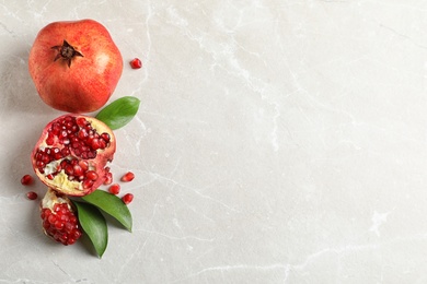 Photo of Flat lay composition with ripe pomegranates and space for text on light background