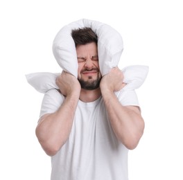 Photo of Tired man covering ears with pillow on white background. Insomnia problem