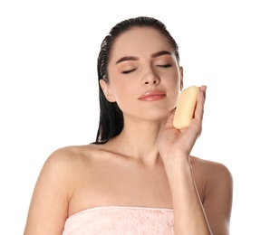 Young woman with soap bar on white background