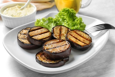 Plate with fried eggplant slices on table