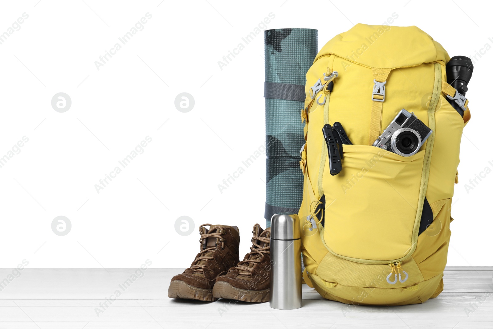 Photo of Set of tourist equipment on wooden surface against white background. Space for text