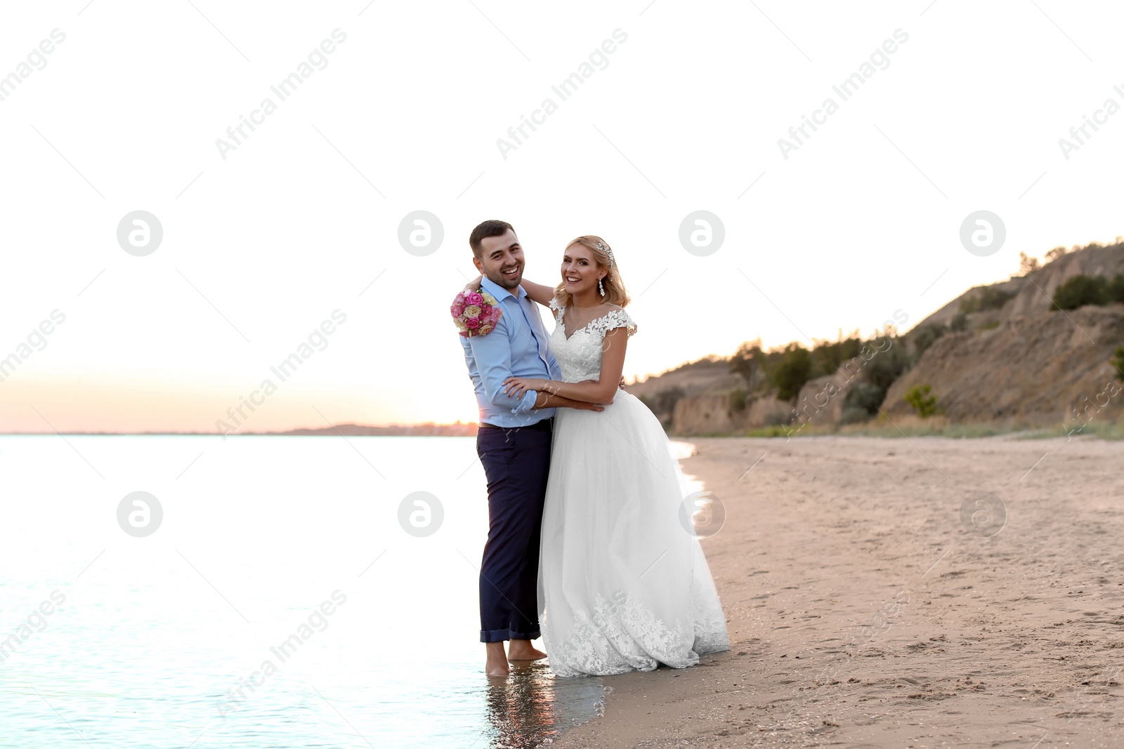 Photo of Wedding couple. Bride and groom standing on beach